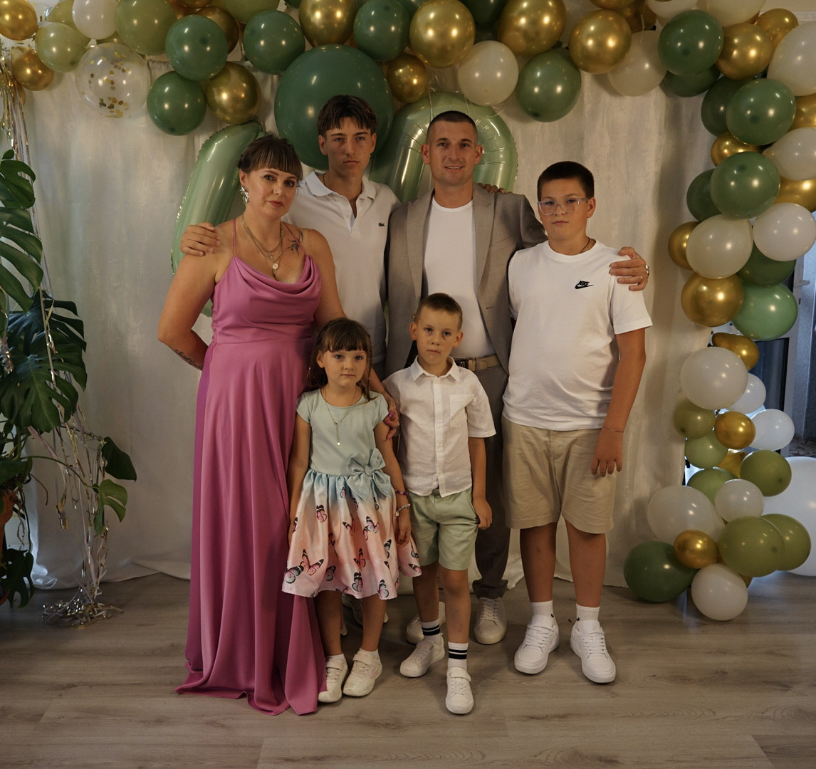 Familienporträt vor der salbeigrünen Ballonwand